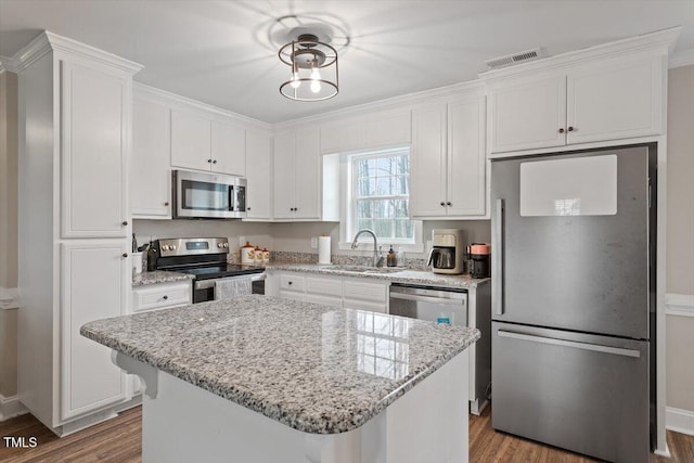 kitchen featuring white cabinets, appliances with stainless steel finishes, and a sink