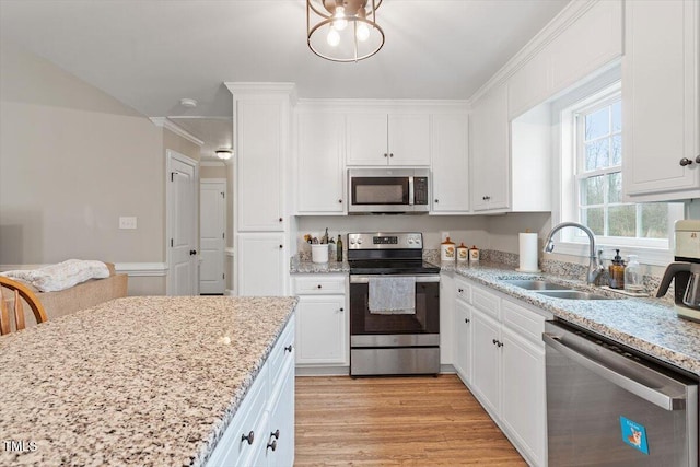 kitchen with light wood finished floors, appliances with stainless steel finishes, white cabinetry, and a sink