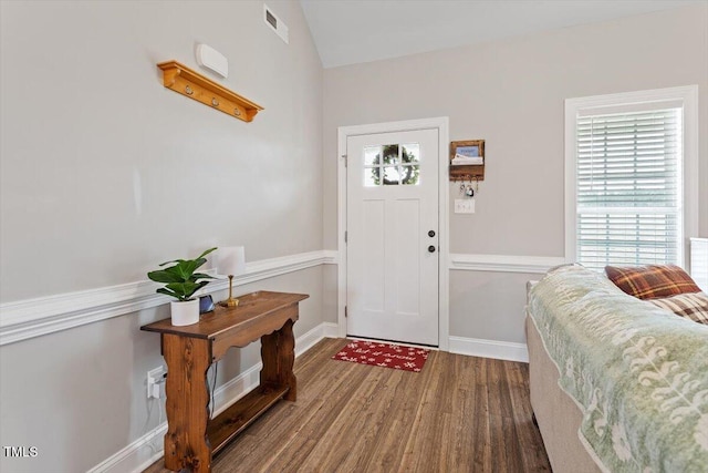 entryway featuring vaulted ceiling, visible vents, baseboards, and wood finished floors