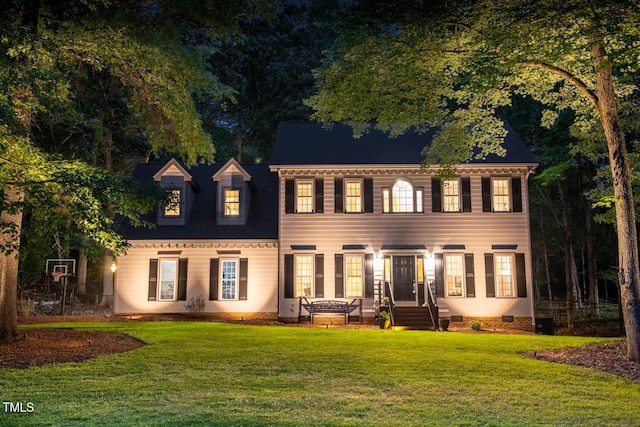 back of house with a lawn and crawl space