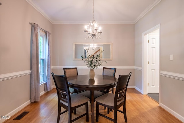 dining space featuring ornamental molding, a notable chandelier, visible vents, and light wood-type flooring