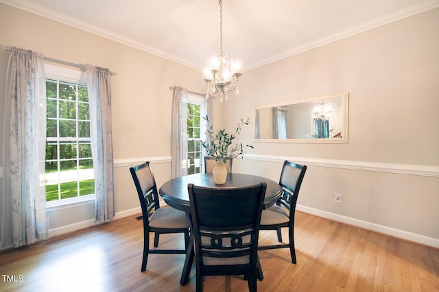 dining area featuring a chandelier, crown molding, baseboards, and wood finished floors