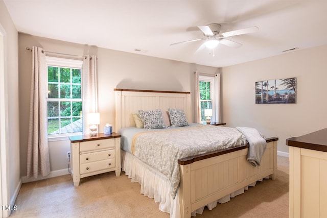 bedroom featuring visible vents, light carpet, and multiple windows