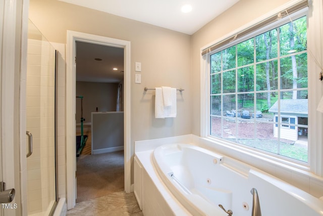 bathroom featuring a tub with jets and a shower stall