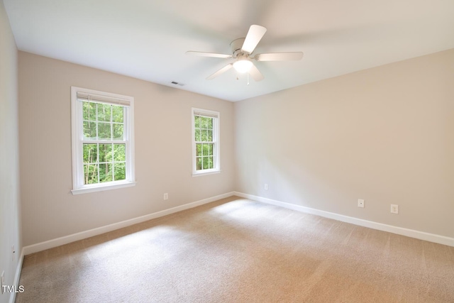 unfurnished room with light colored carpet, visible vents, and baseboards