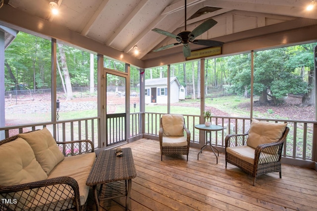 sunroom / solarium featuring vaulted ceiling with beams and a ceiling fan