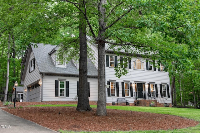 colonial house with crawl space, a front lawn, roof with shingles, and an attached garage