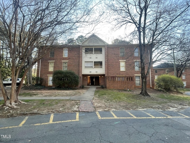 view of front of property featuring uncovered parking and brick siding