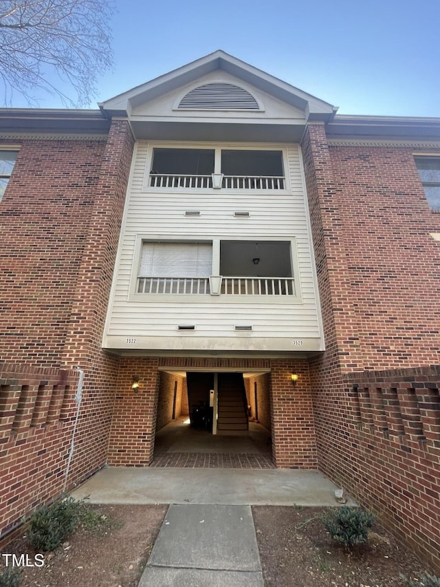 view of front facade featuring a balcony and brick siding