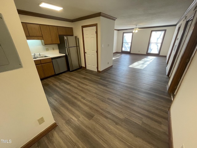 kitchen featuring dark wood-type flooring, crown molding, dishwasher, freestanding refrigerator, and a sink