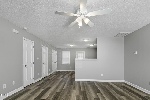 empty room with visible vents, baseboards, dark wood-style flooring, ceiling fan, and a textured ceiling