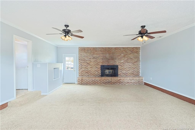 unfurnished living room featuring ceiling fan, carpet floors, ornamental molding, a wood stove, and a textured ceiling