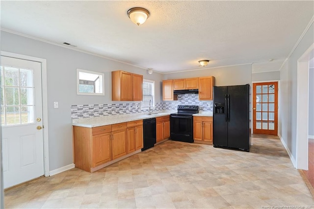 kitchen with a sink, black appliances, light countertops, under cabinet range hood, and backsplash