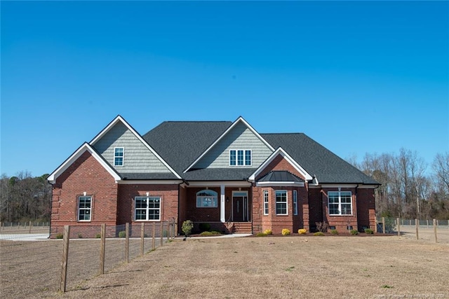 craftsman house featuring crawl space, brick siding, a shingled roof, and fence