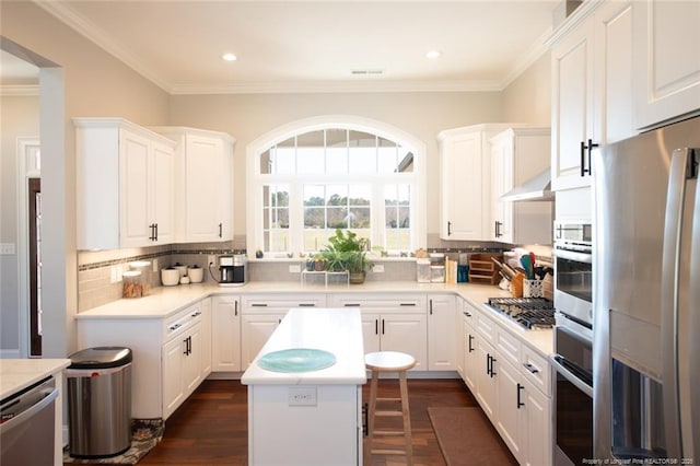 kitchen with stainless steel appliances, white cabinets, and decorative backsplash