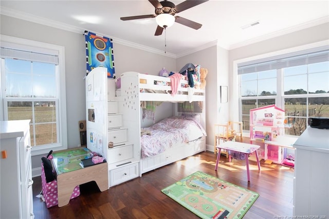 bedroom with ceiling fan, visible vents, wood finished floors, and ornamental molding