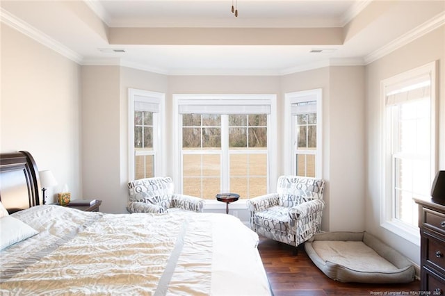 bedroom featuring dark wood finished floors, visible vents, and a tray ceiling