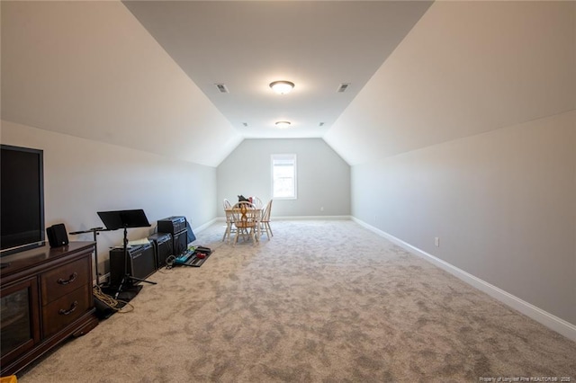 interior space featuring lofted ceiling, carpet flooring, visible vents, and baseboards