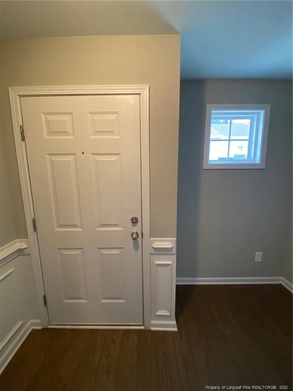 doorway featuring dark wood-style floors and baseboards