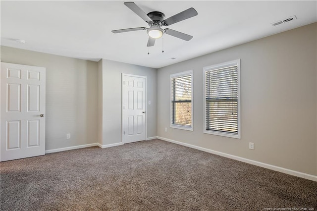 unfurnished bedroom with carpet flooring, visible vents, a ceiling fan, and baseboards