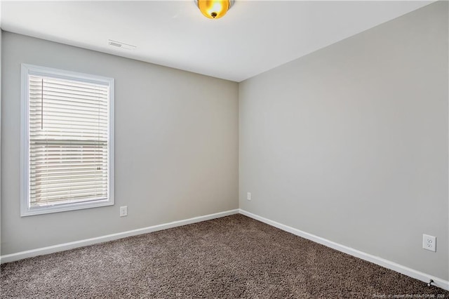 spare room with visible vents, carpet flooring, and baseboards