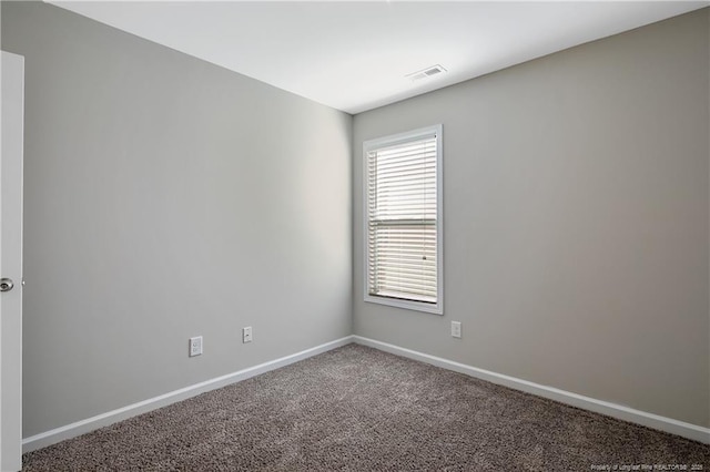 carpeted spare room featuring visible vents and baseboards