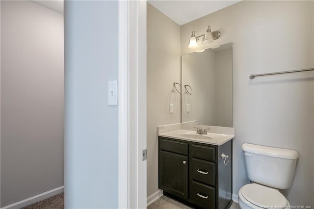 bathroom featuring toilet, vanity, and baseboards