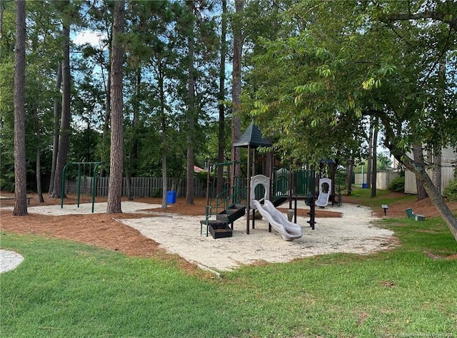 community play area featuring a yard and fence