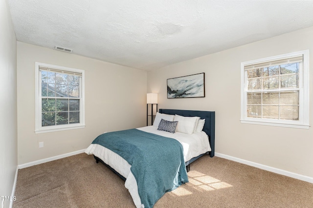 bedroom featuring visible vents, multiple windows, baseboards, and carpet floors