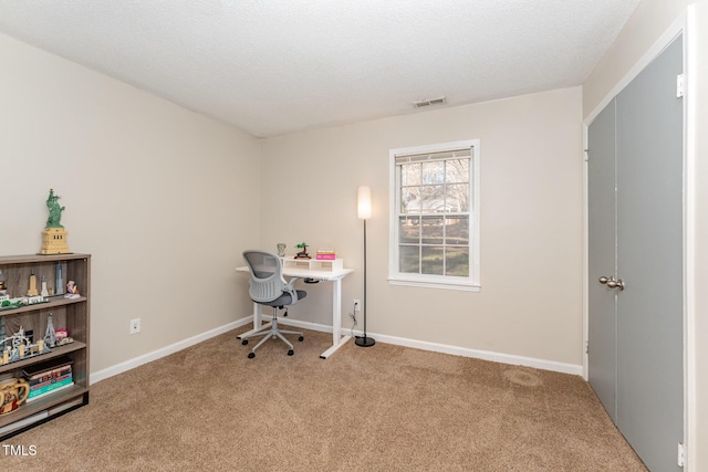 home office featuring visible vents, a textured ceiling, baseboards, and carpet floors