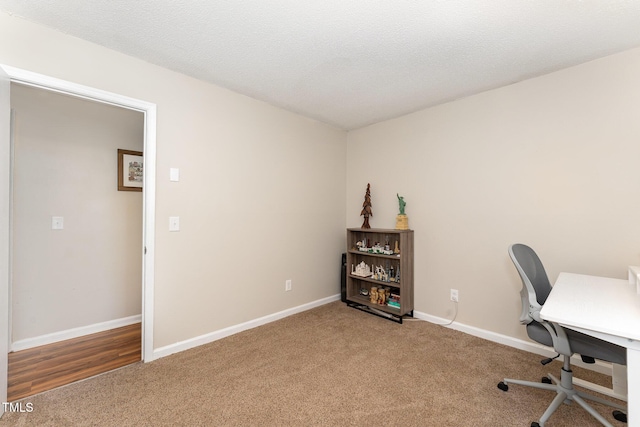 unfurnished office with baseboards, carpet floors, and a textured ceiling