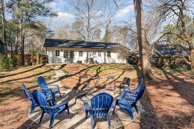 rear view of house featuring an outdoor fire pit, a patio, and fence