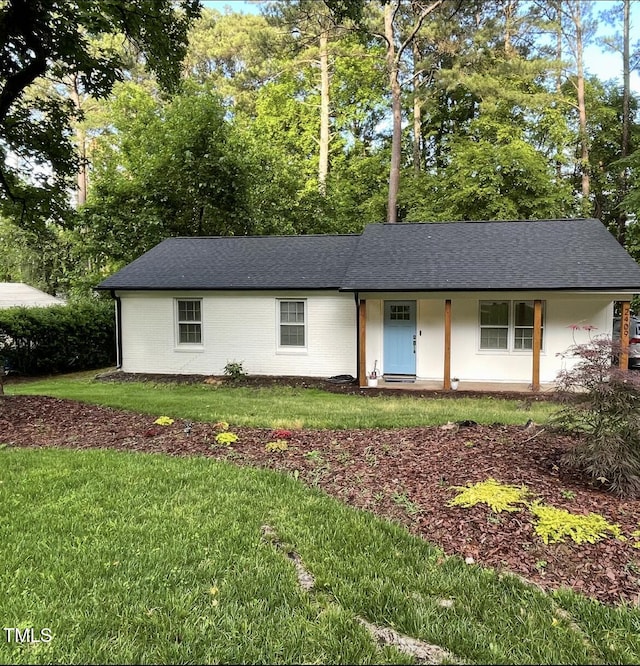 ranch-style house with a front yard and a shingled roof