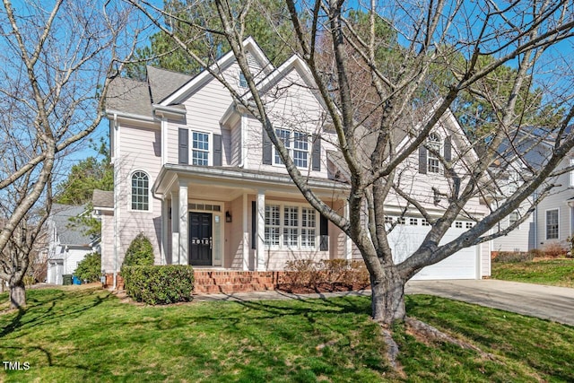 traditional-style home with a front lawn, a garage, and driveway