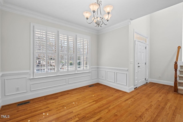 unfurnished dining area featuring light wood-type flooring, visible vents, a notable chandelier, and ornamental molding