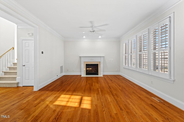 unfurnished living room featuring visible vents, a ceiling fan, and ornamental molding