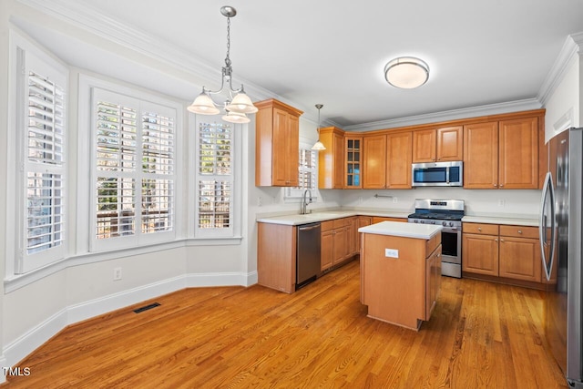 kitchen featuring light wood finished floors, a sink, stainless steel appliances, light countertops, and a chandelier