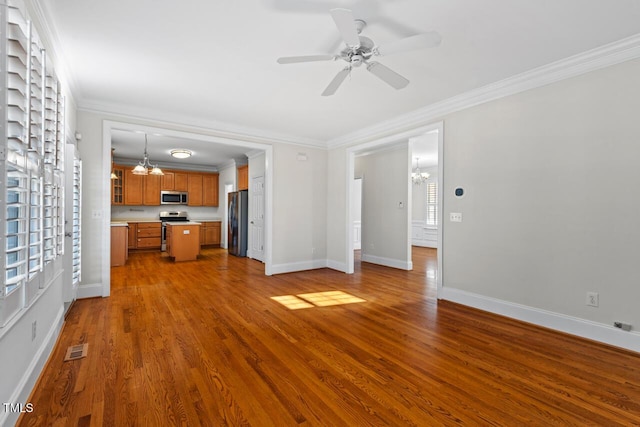 unfurnished living room with dark wood finished floors, baseboards, visible vents, and ornamental molding