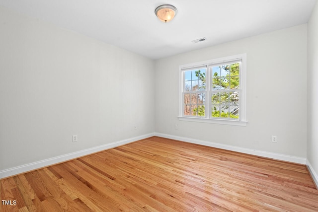 spare room with baseboards, visible vents, and light wood-type flooring