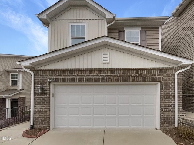 traditional-style home with brick siding, concrete driveway, and a garage