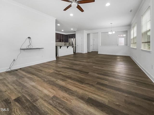 unfurnished living room featuring baseboards, visible vents, dark wood-style flooring, and ornamental molding