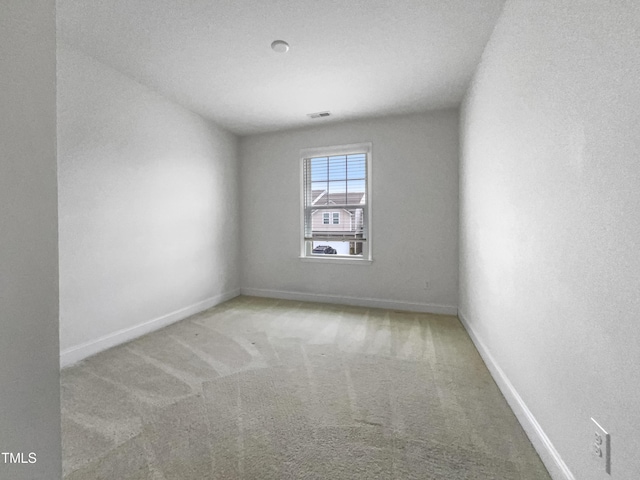 carpeted empty room featuring baseboards