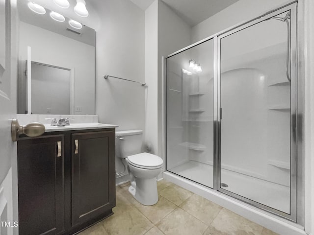 bathroom featuring tile patterned floors, a stall shower, toilet, and vanity