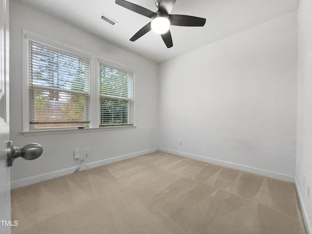 unfurnished room featuring visible vents, light colored carpet, baseboards, and ceiling fan