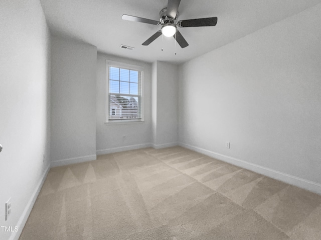 unfurnished room with visible vents, baseboards, carpet, and a ceiling fan