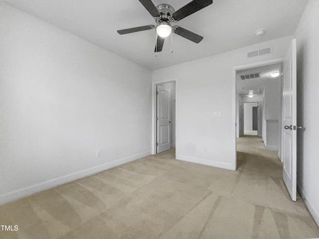 unfurnished bedroom featuring visible vents, light colored carpet, baseboards, and ceiling fan