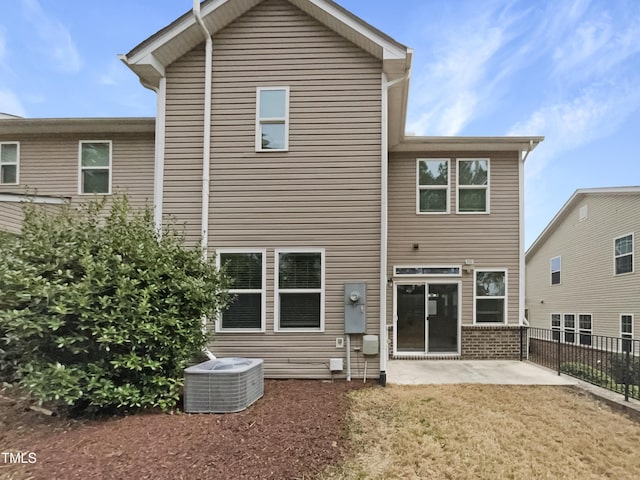 rear view of house featuring central air condition unit, a patio, brick siding, and fence