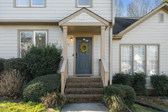 property entrance featuring roof with shingles