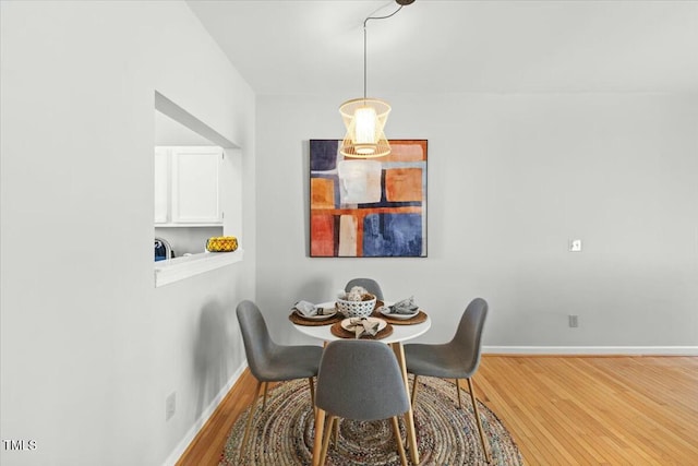 dining area featuring baseboards and wood finished floors