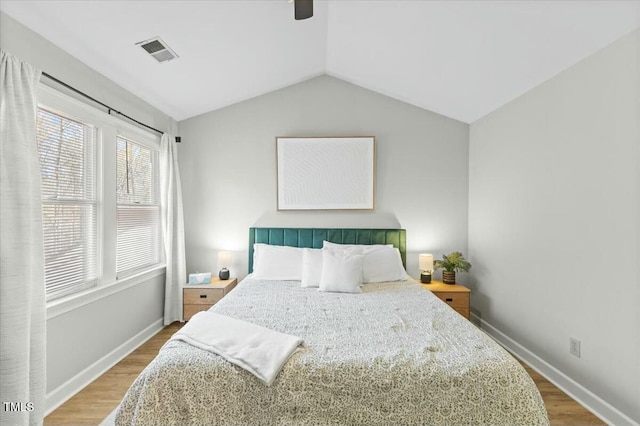 bedroom featuring visible vents, wood finished floors, baseboards, lofted ceiling, and ceiling fan